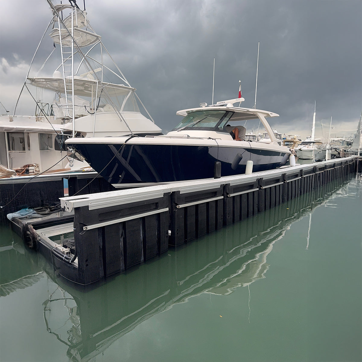 Boats docked at a marina with a cloudy sky