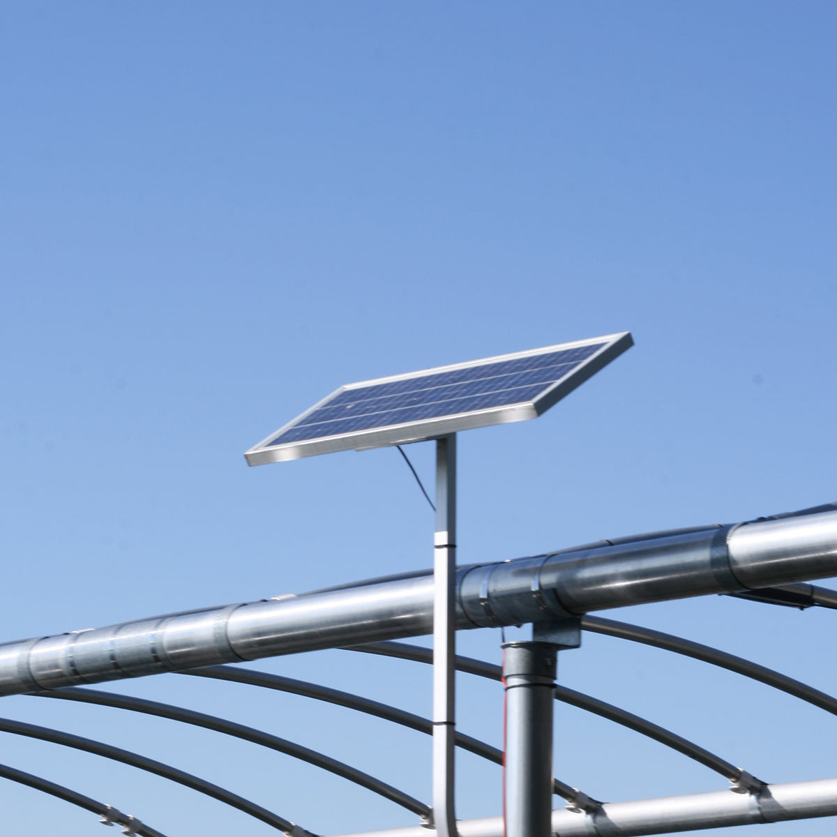 Solar panel on a metal structure against a clear blue sky