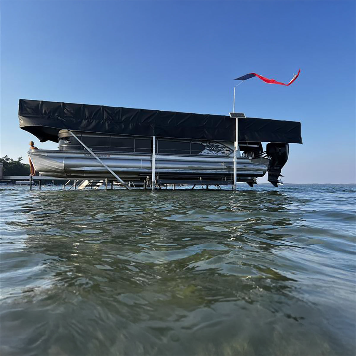 Pontoon boat on water with a clear blue sky