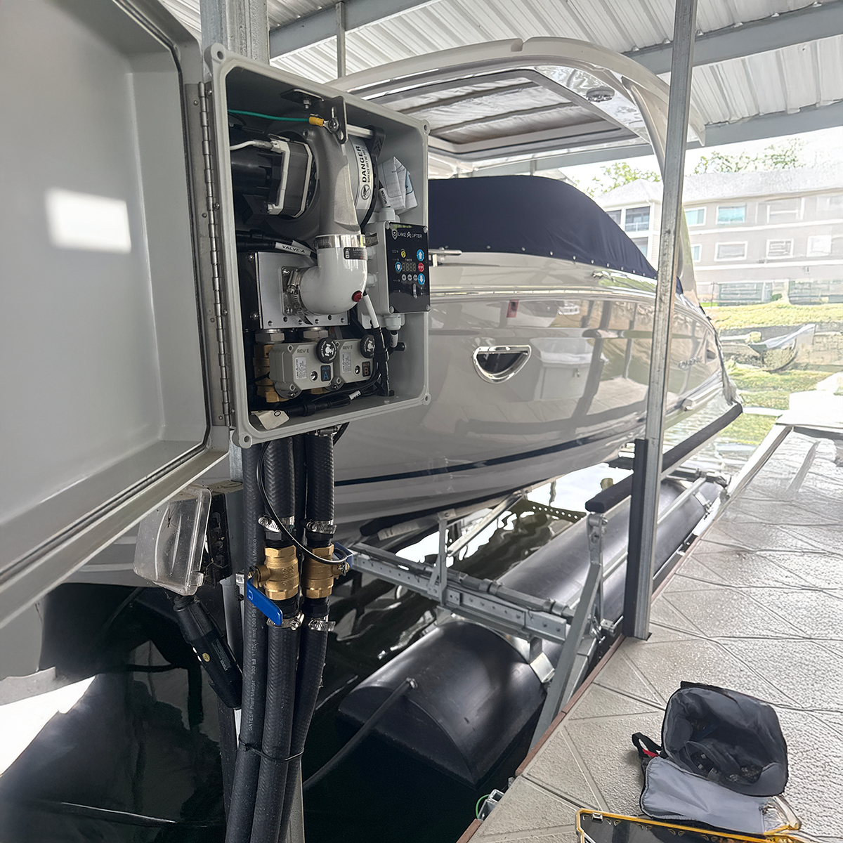 Boat with open compartment showing engine and controls on a dock.