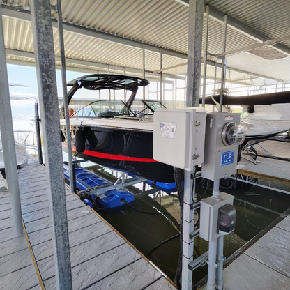 Boat lift system with a boat partially submerged in water at a dock.