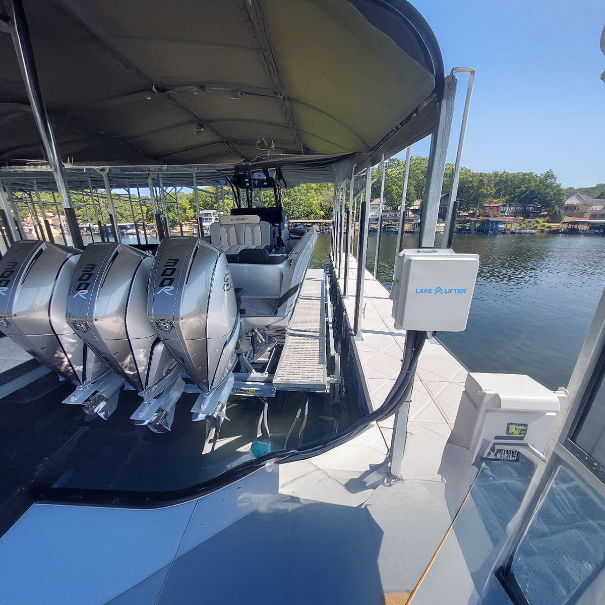 Boat with outboard motors on a dock with water and trees in the background