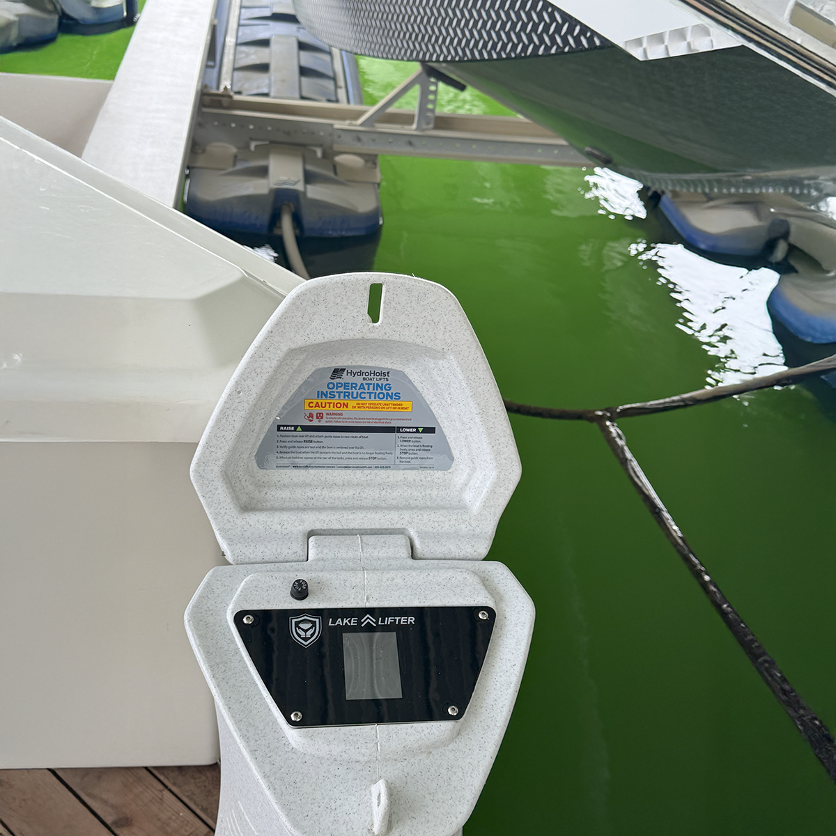 Lake Liftier boat lift system with green water and dock in the background