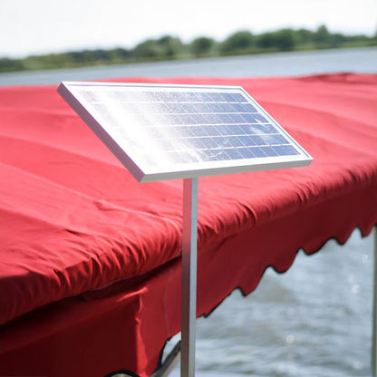 Solar panel on a red awning with a blurred water and sky background