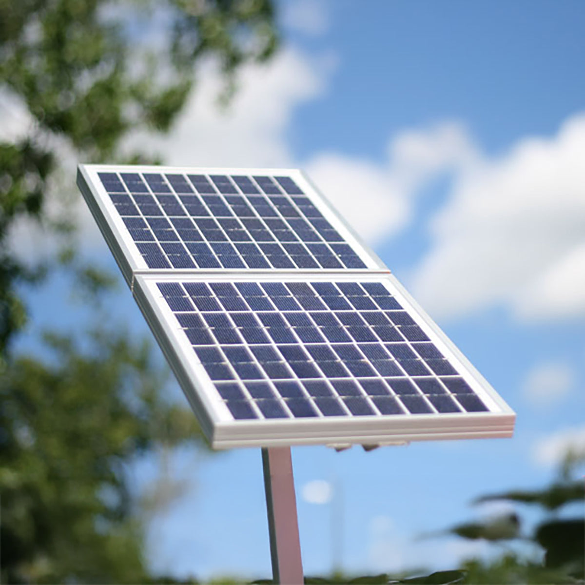 Solar panel on a stand with trees and blue sky in the background