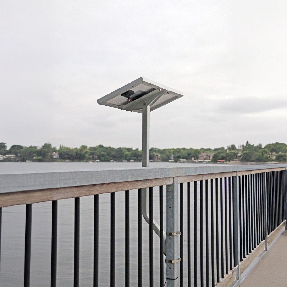 Solar panel on a dock with water and trees in the background