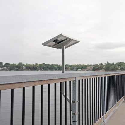 Solar panel on a dock with water and trees in the background