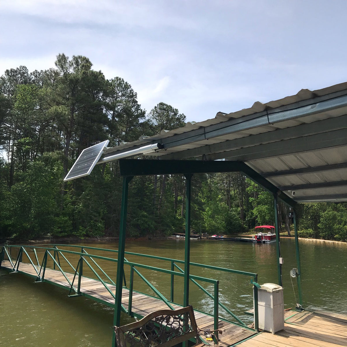 Solar panel on a dock with a lake and trees in the background