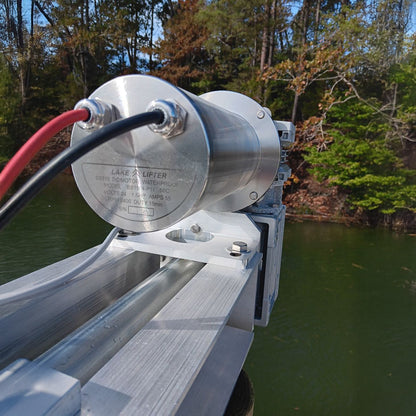 Metal lift mechanism on a dock with water and trees in the background